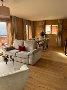 un salon avec un canapé et une table dans l'établissement Dent Blanche Resort - TemptingPlaces Collection, à Hérémence