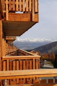 une terrasse en bois avec vue sur les montagnes enneigées dans l'établissement Dent Blanche Resort - TemptingPlaces Collection, à Hérémence
