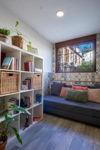 ein Wohnzimmer mit einer Couch und einem Bücherregal in der Unterkunft Oripando Hostel in Granada