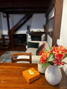 ein Tisch mit einer Vase mit Blumen darauf in der Unterkunft San Pietro Home in Ferrara
