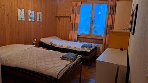 ein kleines Zimmer mit zwei Betten und einem Fenster in der Unterkunft Preschaint (720 Kü) in Valbella + 5 Fotos