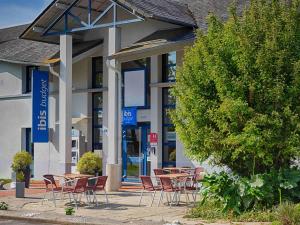a group of tables and chairs in front of a building at ibis budget Redon in Redon