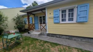 a yellow house with blue windows and a door at Letoilevelli in Salazie +6 photos