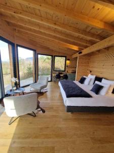 a large bedroom with a large bed and windows at Cocooon Wood, hébergement insolite Savoie in Saint-Paul-sur-Yenne