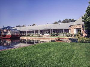un grand bâtiment avec un pont sur une étendue d'eau dans l'établissement Mercure Ballarat Hotel & Convention Centre, à Ballarat