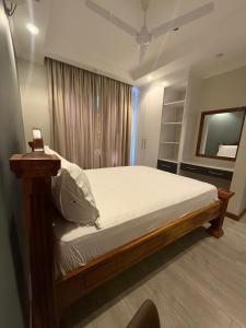 une chambre avec un lit avec des draps blancs et une fenêtre dans l'établissement BenRoche place, à Kilifi