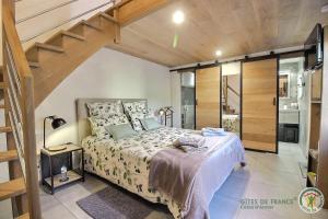 une chambre avec un lit et un escalier dans l'établissement Le bel arbre, à Tressignaux