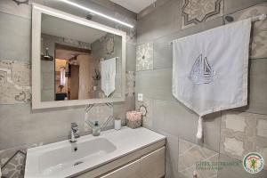 une salle de bain avec un lavabo et un miroir dans l'établissement Le bel arbre, à Tressignaux