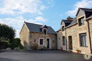 une maison en pierre avec une allée en face de celle-ci dans l'établissement Le bel arbre, à Tressignaux