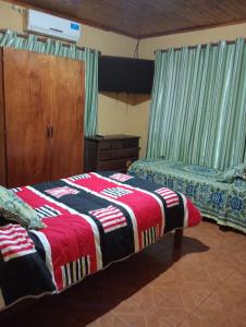 ein Schlafzimmer mit zwei Betten und einer Kommode und einem Bett sidx sidx sidx sidx in der Unterkunft Silvia in Puerto Libertad