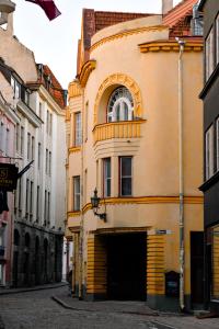 a yellow building with a window on a street at Bolero Apart in Tallinn
