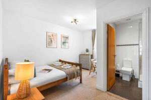 a bedroom with a bed and a bathroom at Queens Cove with Seaviews By My Getaways in Worthing