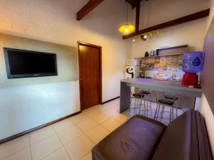 a kitchen with a counter and a bar with stools at Pousada Kauai in Imbituba