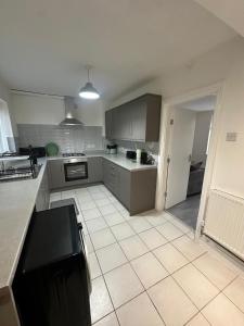 une grande cuisine avec carrelage blanc et appareils électroménagers dans l'établissement Blackthorne House, à Birmingham