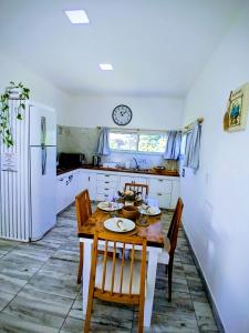 eine Küche mit einem Tisch und Stühlen sowie einer Uhr an der Wand in der Unterkunft Casa con Jardín Las Marías 2 in Miramar