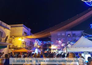 Una multitud de personas en un evento al aire libre por la noche. en Sole E Mare, en Guardia Piemontese Terme