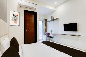 a hotel room with a bed and a tv at Super Townhouse Hotel Sec- 54 Golf Course Road in Gurgaon +23 photos