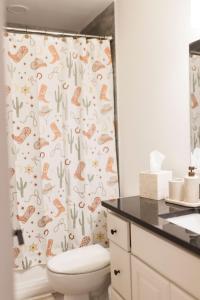 une salle de bain avec toilettes et rideau de douche dans l'établissement The Rodeo House - Near Rodeo Arena, à Mesquite