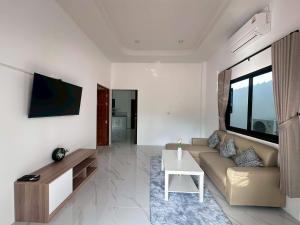 a living room with a couch and a table at Grandma's Samui Garden - บ้านสวนคุณย่า in Ban Tai