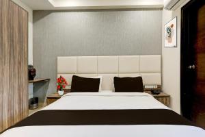 a bedroom with a large white bed with black pillows at Super Townhouse Hotel Sec- 54 Golf Course Road in Gurgaon