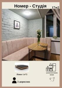 un soggiorno con un divano e un tavolo di Бюджетна студія біля ратуші a Černivci