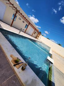 a bottle of beer sitting next to a swimming pool at Chácara de vidro in Canindé de São Francisco