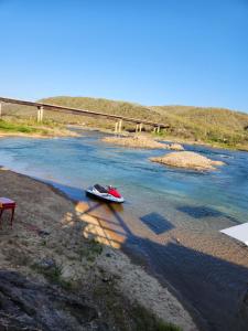 un bateau assis sur la rive d'une rivière dans l'établissement Chácara de vidro, à Canindé de São Francisco