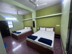 deux lits dans une chambre aux murs verts dans l'établissement The Golden Seaview - Homestay, à Gokarna