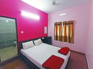 - une chambre avec un grand lit aux murs roses dans l'établissement The Golden Seaview - Homestay, à Gokarna 7 autres photos