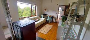 ein Wohnzimmer mit einer Couch und einem Fenster in der Unterkunft Anahata Lodge, Alojamiento Tranquilo en Medio de la Naturaleza in Puerto Varas