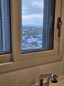 a window over a sink with a view of a city at 청라 스테이 22층 뷰 공항 송도 검단 김포 in Kojan