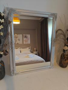- un miroir reflétant un lit dans une chambre dans l'établissement Stefani retro luxury apartments, à Chalcis