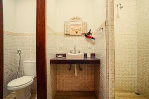 une salle de bain avec toilettes, lavabo et douche dans l'établissement Pousada Recanto dos Pássaros, à Visconde de Mauá
