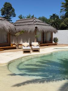 a resort with two chairs and a swimming pool at Tribu Eco Beach in Francisco Álvarez