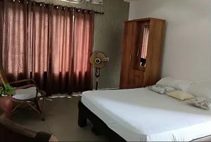 科钦G Hotels And Resorts的一间卧室，里面有一张床、一把椅子和一扇窗户