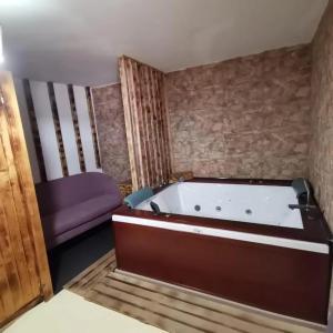 uma banheira num quarto com um sofá roxo em Modern Villa in Yebra with Private Pool em Yebra