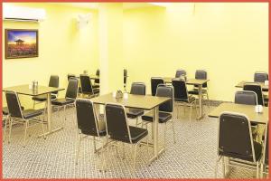 普里BALCONY ROOMS Hotel PREMIUM RR RESIDENCY Near Jagannath Temple - Sea Beach 5 minute walking distance - Bangali Market- Lift-Parking And Restaurant Facilities -Prime Location - Fully Air Conditioning Luxuary Rooms - Top Rated Hotel In Puri的房间里有桌椅的教室