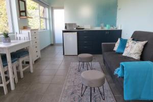 un salon avec un canapé et une table et une cuisine dans l'établissement The Sundowner Room, à Langebaan