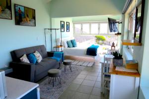 a living room with a couch and a bed at The Sundowner Room in Langebaan