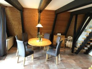 une salle à manger avec une table et des chaises en bois dans l'établissement Tossi Haus 107 In Fedderwardersiel, à Butjadingen