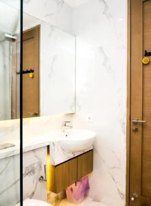 ein Badezimmer mit Waschbecken und Spiegel in der Unterkunft 1 BD AT Coastal Skyline in Hongkong