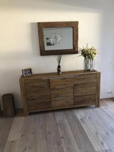un tocador de madera en una habitación con flores. en Motta Rotonda, en Maloja