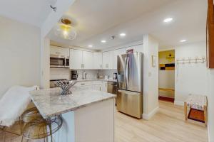 une cuisine avec des armoires blanches et un réfrigérateur en acier inoxydable dans l'établissement Mountain Green: 2E2, à Killington