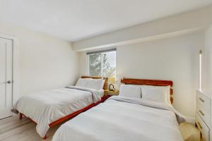 Ce lit se trouve dans un dortoir doté de murs blancs et d'une fenêtre. dans l'établissement Mountain Green: 2E2, à Killington