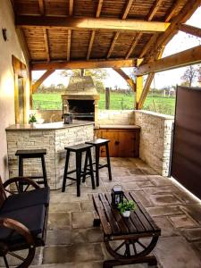 une terrasse avec deux tables et une cuisine extérieure dans l'établissement Terrasse couverte et BBQ - Petite maison cosy, à Magnet