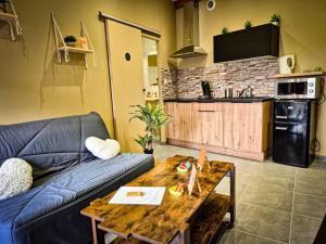 un salon avec un canapé bleu et une table dans l'établissement Terrasse couverte et BBQ - Petite maison cosy, à Magnet 10 autres photos