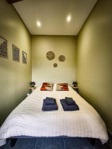 une chambre avec un lit avec deux serviettes dessus dans l'établissement Terrasse couverte et BBQ - Petite maison cosy, à Magnet