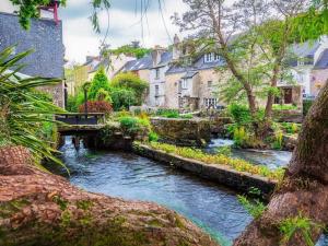 einen Fluss in einer Stadt mit Häusern und einer Brücke in der Unterkunft Mobil-home 8 personnes camping PONT AVEN - WIFI GARANTIE-grande terrasse-lave linge in Pont-Aven