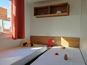 ein Schlafzimmer mit zwei Betten mit einem ausgestopften Tier darauf in der Unterkunft Mobil-home 8 personnes camping PONT AVEN - WIFI GARANTIE-grande terrasse-lave linge in Pont-Aven