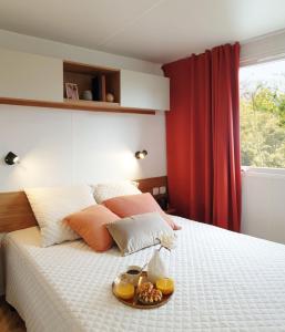 ein Schlafzimmer mit einem Bett, auf dem ein Tablett mit Essen steht in der Unterkunft Mobil-home 8 personnes camping PONT AVEN - WIFI GARANTIE-grande terrasse-lave linge in Pont-Aven